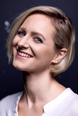 Das Portrait zeigt Lina Ritters mit kurzen kinnlangen, blonden Haaren und einem warmen Lächeln.