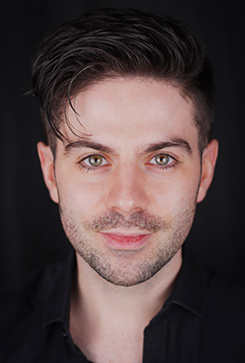 Das Portrait zeigt Chris Green mit kurzen, dunklen Haaren, grünlichen Augen und einem dezenten Lächeln.