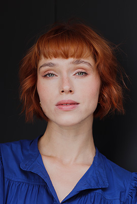 Das Portrait zeigt Larissa Winkel mit kinnlangem, roten Haaren. Sie trägt eine blaue Bluse.