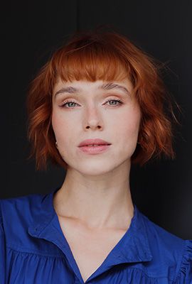 Das Portrait zeigt Larissa Winkel mit kinnlangem, roten Haaren. Sie trägt eine blaue Bluse.