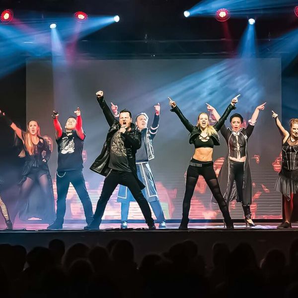 Energiegeladene We Will Rock You-Szene der Best of Musicals Show: Rockige Outfits, dynamische Choreografie und starke Posen – die Darsteller bringen die Bühne mit Queen-Feeling zum Beben!