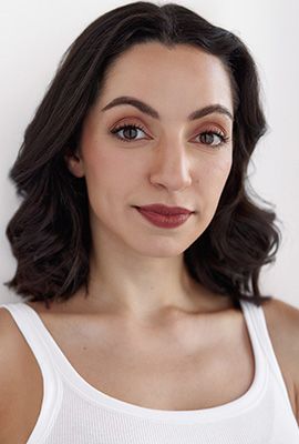 Das Portrait zeigt Amanda Mitrevski mit mittellangen, schwarzen Haaren und einem dezenten Lächeln.