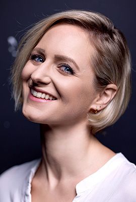 Das Portrait zeigt Lina Ritters mit kurzen kinnlangen, blonden Haaren und einem warmen Lächeln.